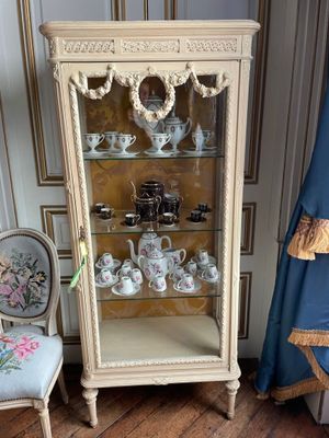 a display case with tea cups and teapots on it