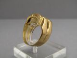 a gold ring sitting on top of a clear stand