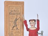 toy figure of a man holding a knife next to a book
