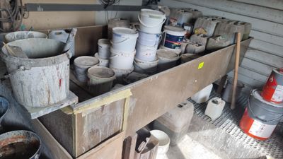 de nombreux seaux posés sur une étagère dans un garage