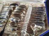 a lot of silver spoons and spoons in a box
