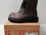 une paire de bottes marron posée sur une boîte