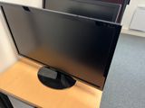 a flat screen tv sitting on top of a wooden table