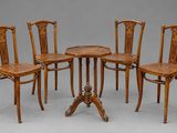 quatre chaises et une table dans une pièce sur fond gris