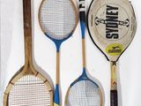 three tennis rackets and a tennis ball on a table