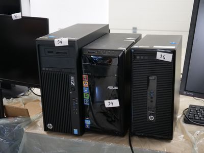 three computers sitting on a table in front of a computer monitor