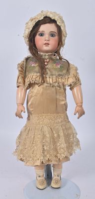 une poupée à l'ancienne, coiffée d'un chapeau et vêtue d'une robe, posée sur un socle
