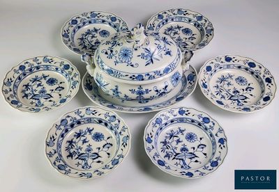 plusieurs assiettes et bols bleus et blancs posés sur une surface blanche