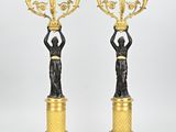 une paire de figurines en bronze représentant une femme tenant un candélabre