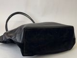 black leather handbag on a white surface with a white background