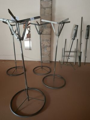 four metal stands that are on the floor in a room