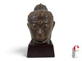 an image of a statue of a buddha head on a wooden base