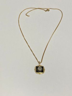 a gold necklace with a black stone pendant on it