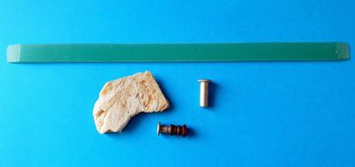 une image représentant un morceau de plastique et une vis sur un fond bleu