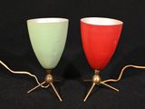 une paire de lampes en verre rouge et vert posées sur une surface noire