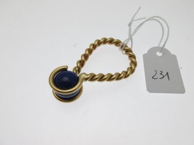 Gros plan sur une bague en or ornée d'une pierre bleue