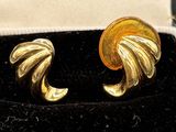 pair of gold tone earrings in a velvet box with black velvet