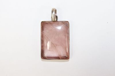 pendentif en verre rose muni d'une bélière en argent, sur fond blanc