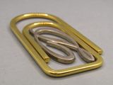 a gold and silver metal buckle on a white surface