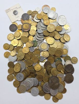 un tas de pièces sur une surface blanche, avec un bout de papier