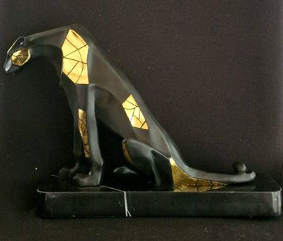 a statue of a cat sitting on top of a black base
