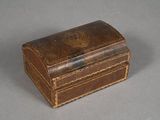 a small brown box with a metal handle on a gray surface