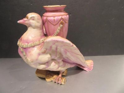 a bird that is sitting next to a vase on a table