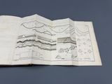 an open book with a drawing of a mountain on it