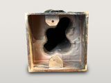 a metal box with a hole in it on a gray background
