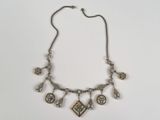 une photo d'un collier en argent orné de diverses breloques