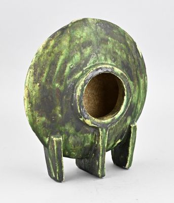 un vase vert qui a un trou au milieu