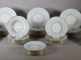 a lot of white and gold plates on a table