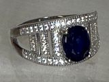une image d'une bague avec une pierre bleue entourée de diamants