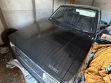 un camion noir garé dans un garage, recouvert d'une couverture jaune