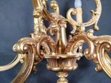 a gold colored chandelier with a candle on it