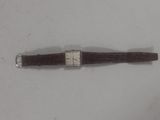 an image of a watch on a white surface with a brown strap