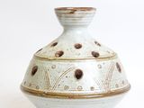 a white and brown vase sitting on a white surface