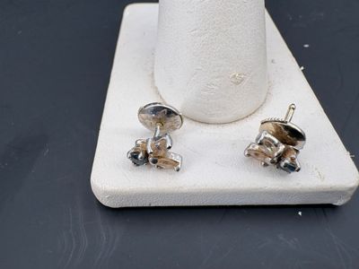 une paire de boucles d'oreilles posée sur un support