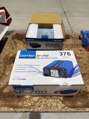 deux boîtes contenant du matériel électronique posées sur une boîte en carton