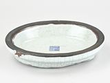 a white bowl with a brown rim on a white surface