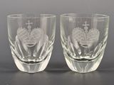 pair of etched glass shot glasses on a black surface
