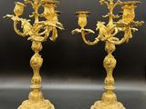 une paire de chandeliers anciens en laiton, ornés d'oiseaux et de fleurs