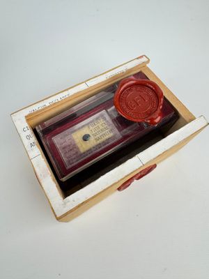 un cachet de cire dans une boîte sur laquelle est apposé un tampon à cire