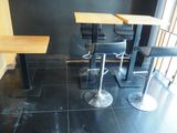 deux tables et deux tabourets dans un coin de la pièce