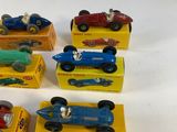 several toy cars are lined up in a row on a white surface