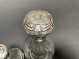 a glass bottle with a silver lid sitting on a table