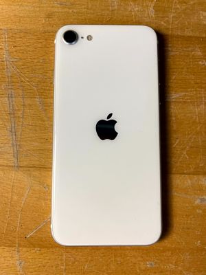 un gros plan d'un iPhone blanc posé sur une table en bois
