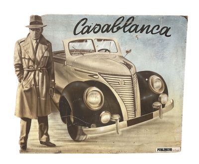 a man standing next to an old car with a hat on