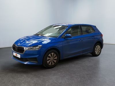 une voiture bleue garée dans une pièce aux murs blancs