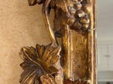 a gold mirror with a bunch of grapes on it